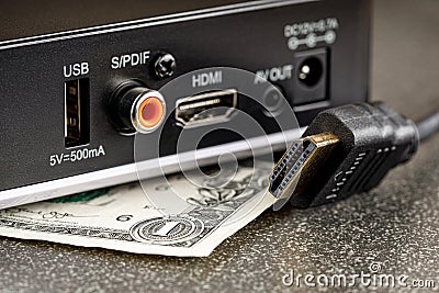 TV box with a disconnected hdmi cable and a dollar under it Stock Photo