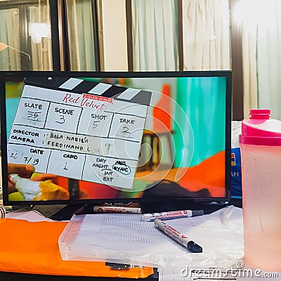 The Tv monitor shows the slate for short commercial video shooting on a messy table Stock Photo
