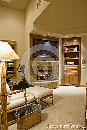 TV Over Fireplace With Reclining Chair In Foreground Stock Photo