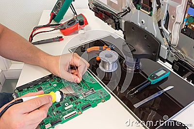 TV repair in the service center, engineer soldering electronic components Stock Photo