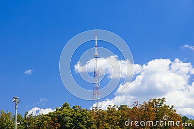 TV tower local infrastructure communication object high metal construction building above green foliage park district clear Stock Photo