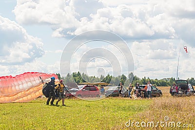 Tandem Paragliding takeoff from the field. Blue sky with clouds Editorial Stock Photo