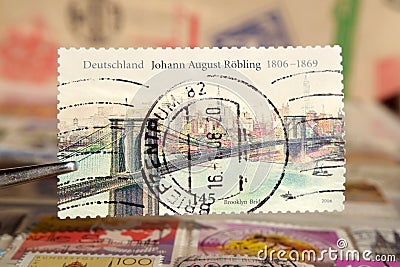 Tweezer holds postage stamp printed by Germany on topic Anniversaries, Shows Johann August Editorial Stock Photo