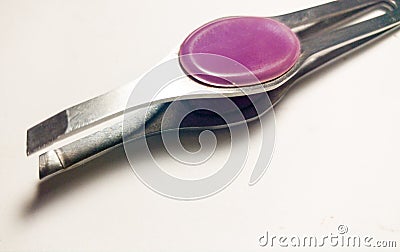 Tweezers with purple handle on white background. Stock Photo