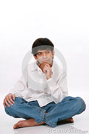 Twelve year old boy sitting, thinking Stock Photo