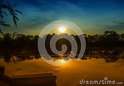 Twilight above the lake and a boat near the coast Stock Photo