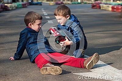 Twin brothers play with a toy car Stock Photo