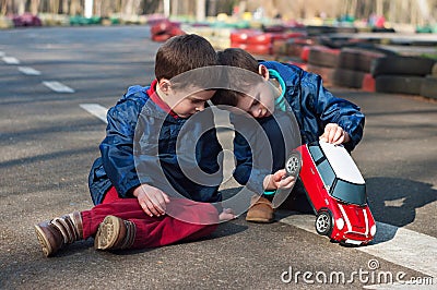 Twin brothers play with a toy car Stock Photo