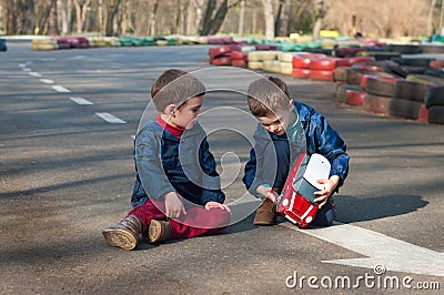 Twin brothers play with a toy car Stock Photo