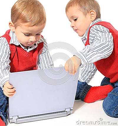 Twin brothers playing woth laptop Stock Photo