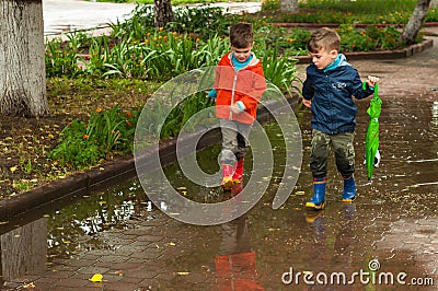 Twin brothers run through a puddle Stock Photo