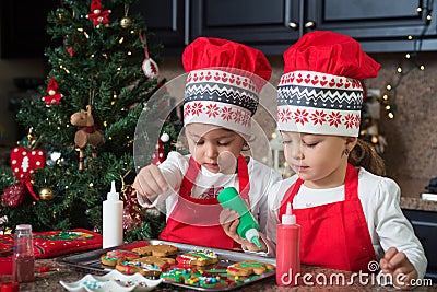 Twin girls in red making Christmas cookies Stock Photo