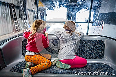 Twin girls riding cabin cable car and enjoying the view. Stock Photo