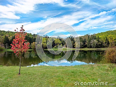 Twin Lakes nestled in the Laurel Highlands of Pennsylvania, beautiful landscape nature scene with a red tree, lake with blue skies Stock Photo