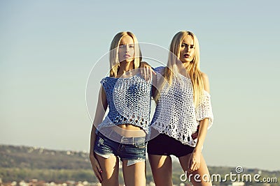 Twin sisters, girls, posing on blue sky Stock Photo