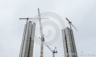 Twin skyscrapers under construction. Building site with multiple tower cranes Stock Photo