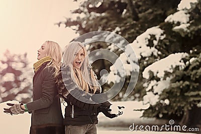 Twin women playing snowballs in forest on snow landscape Stock Photo