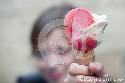 Ice cream in the form of a flower with petals in hand. Boy proudly shows his ice cream cone with vanilla and raspberry ice cream. Editorial Stock Photo