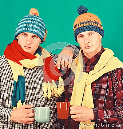 Twins with serious faces hold cups. Autumn season and friendship Stock Photo