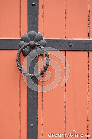Iron doorknocker on orange wooden door Stock Photo