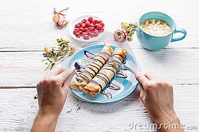 Twisted pancakes watered with chocolate Stock Photo