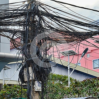 Twisted wires of power lines, chaos of urban communications, cable bundle Stock Photo