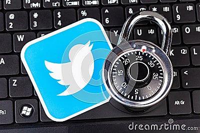 Twitter account password security simple abstract concept. Twitter service logo and a metal coded padlock, lock laying on a black Editorial Stock Photo