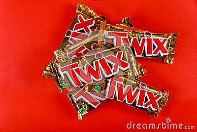 Twix brand candy in large bars with caramel and milk chocolate made by Mars, Inc. on red background Editorial Stock Photo