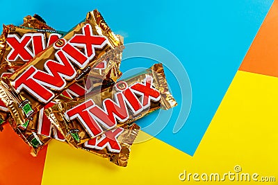 Twix is a chocolate bar made by Mars, Inc., with caramel and milk chocolate A close-up of Twix cookie bars candy bars on orange Editorial Stock Photo