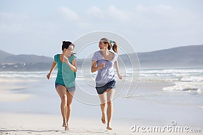 Two active women running and enjoying life at the beach Stock Photo