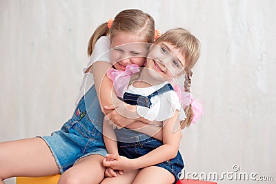 Two adorable little sisters laughing and hugging each other Stock Photo
