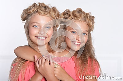 Two adorable twin sisters in beautiful pink dresses Stock Photo