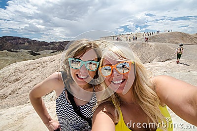 Two adult females take a selfie while at Zabriskie Point lookout in California Death Valley National Park Stock Photo