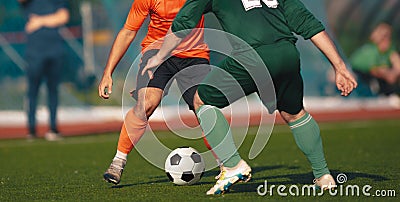 Two adult football players kicking a soccer ball in a duel. Soccer competition between two teams Stock Photo