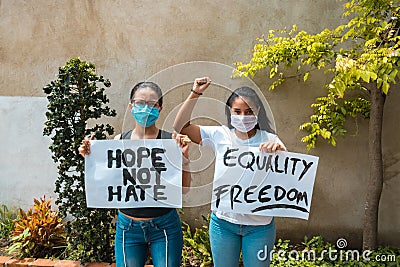 Two African-American women protesting holding signs Stock Photo