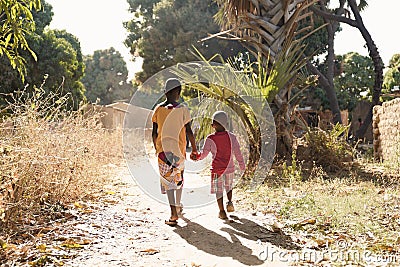 Two African Children Walk Down Natural Road in African Village Stock Photo