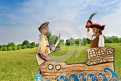 Two African kids as pirates dueling with swords Stock Photo