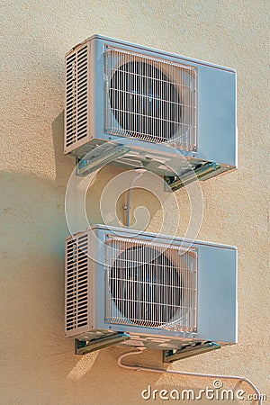 Two air conditioning external units mounted on th wall of residential building Stock Photo