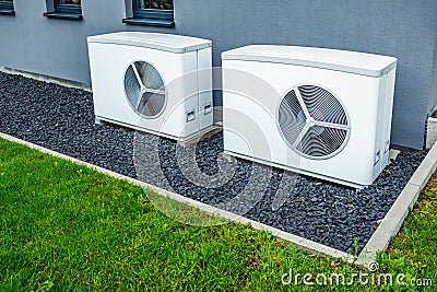 Two air source heat pumps installed outside of new and modern city house, green renewable energy concept of heat pump Stock Photo