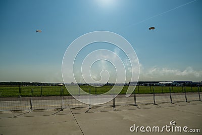 Two airships over a green field on a background of blue sky and sunlight. Stock Photo