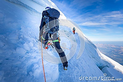 Two alpinists mountaineers climbing over ice crevasse Stock Photo