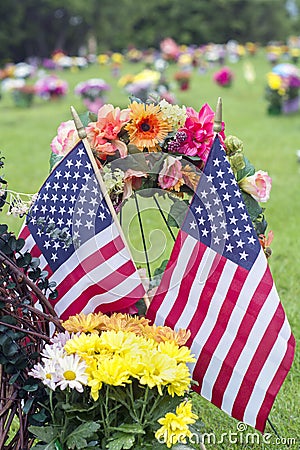 Two American flag and Flowers on veteran Graveside Stock Photo