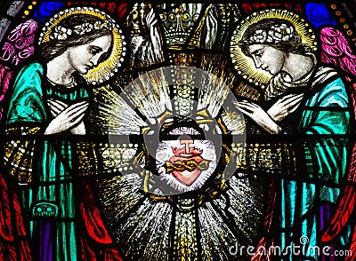 Two angels with the sacred heart in stained glass Stock Photo