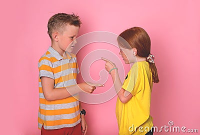 Two angry kids brother and sister standing face to face, pointing fingers to each other, shouting and blame. School Stock Photo