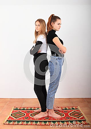Two angry teenage girls standing on oriental carpet Stock Photo