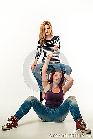 Two angry women connected by a pair of handcuffs Stock Photo