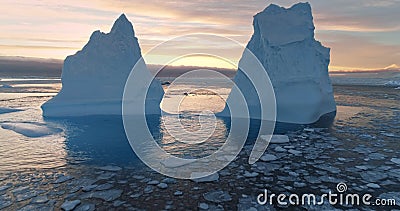 Two Antarctic melting icebergs in sunset landscape Stock Photo