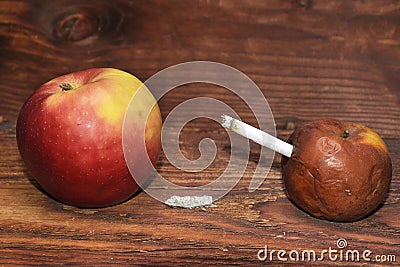 Two apples and a cigarette in wood background. smoke kills. No smok Stock Photo