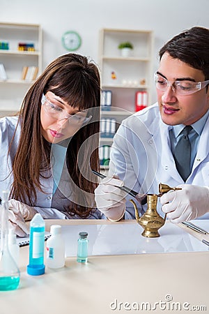 The two archeologists looking at ancient gold lamp Stock Photo