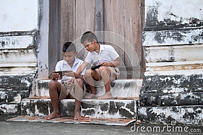 Two asian boys wearing school uniforms are playing game but they Stock Photo